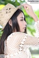 A woman wearing a straw hat is posing for a picture.