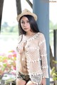 A woman in a straw hat is posing for a picture.