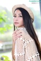 A woman with long black hair wearing a straw hat.