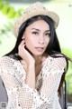 A woman wearing a straw hat sitting on a chair.