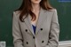 a woman standing in front of a blackboard wearing a suit