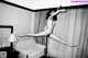 A naked woman is jumping in the air in a hotel room.