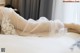 A woman in a wedding dress laying on a bed.