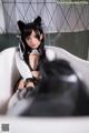 A woman in a cat costume sitting in a bathtub.