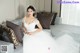 A woman in a wedding dress sitting on a couch.