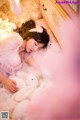 A woman laying on a bed with a stuffed animal.