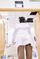 A woman in a white lab coat is standing in a hospital room.