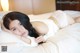 A woman laying on a bed in a white lingerie.