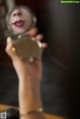 A woman holding a mirror in front of her face.